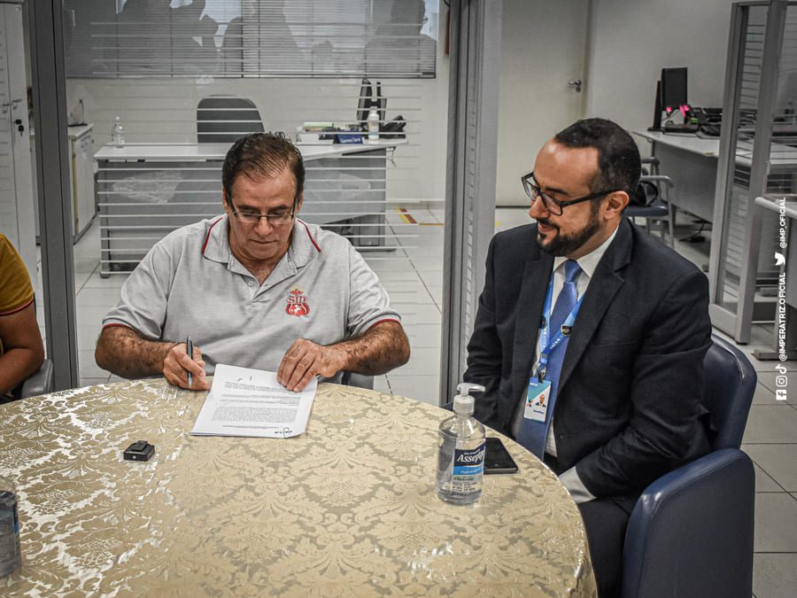 Presidente Wagnner Ayres assina contrato observado pelo Superintendente da Caixa, Jonathan Valença.